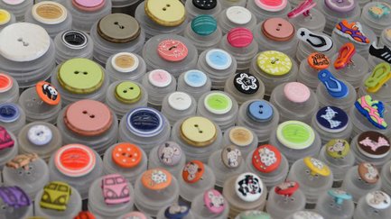 Viele bunte Knöpfe in verschiedenen Farben, Motiven und Designs liegen dicht beisammen.