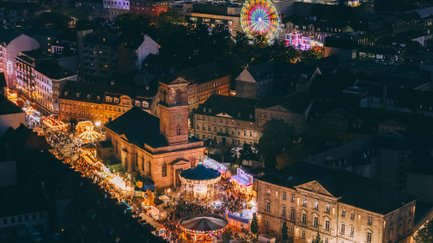 Luftaufnahme der Michaelis-Kirchweih in Fürth bei Nacht mit Riesenrad, Kettenkarussell, Buden und Besuchern.