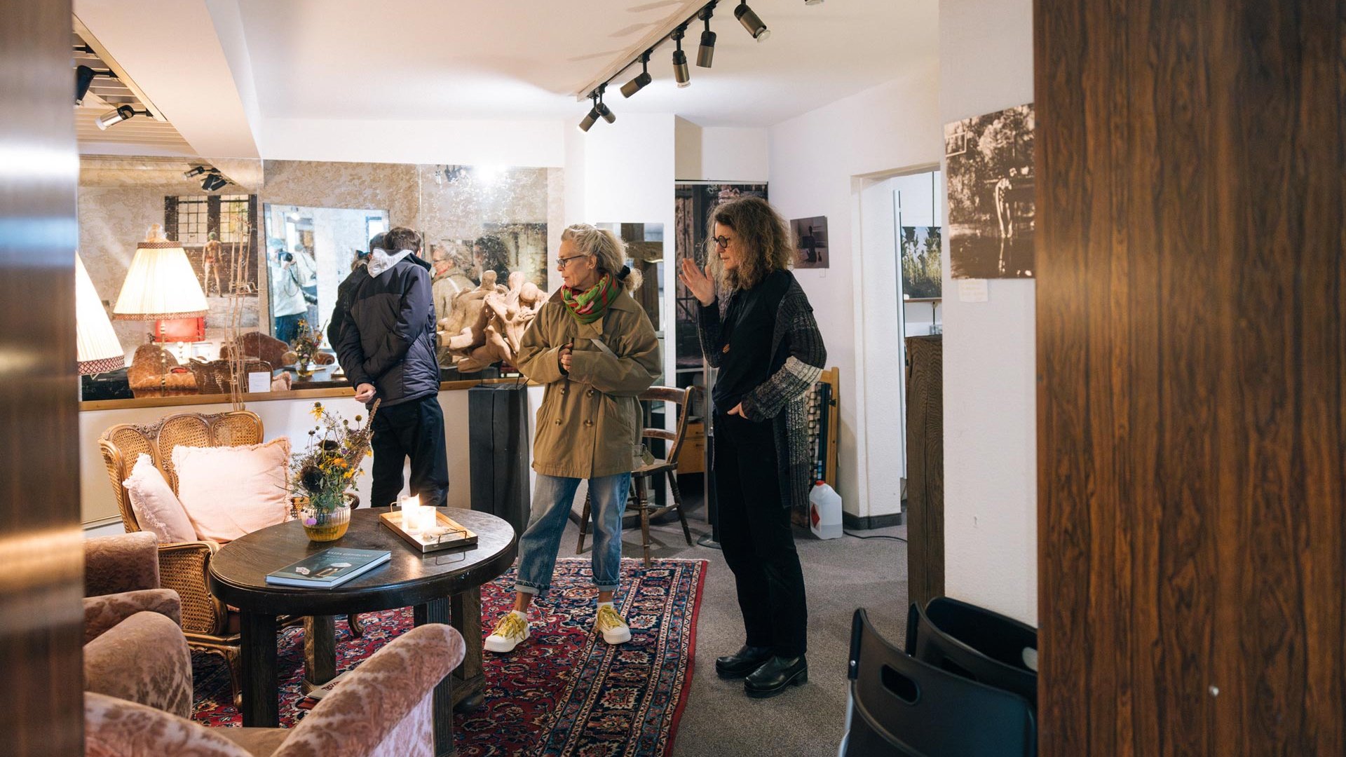Drei Personen stehen in einem wohnzimmerartigen Atelier in Fürth, umgeben von dekorativer Kunst