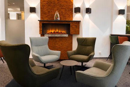 Stilvolle Sitzrunde vor einem offenen Kamin im Excelsior Hotel Nürnberg Fürth mit elegantem Ambiente