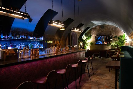 Langer Raum im Kellergewölbe von Castros Bar mit moderner Bar, Sandsteinwänden und gemütlicher Atmosphäre