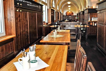 Rustikaler Gastraum im Grüner Brauhaus Fürth mit Holzverkleidung, Holztischen und Stühlen