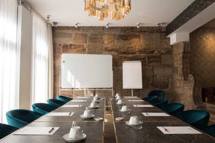 Heller Tagungsraum Freiraum im Werners Boutique Hotel Fürth mit Sandsteinwand, Tischen, Stühlen und Flipchart