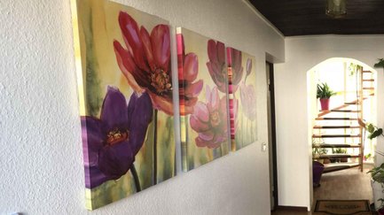 Eingangsbereich des Apartments Falke in Fürth mit dekorativen Blumenbildern an der Wand