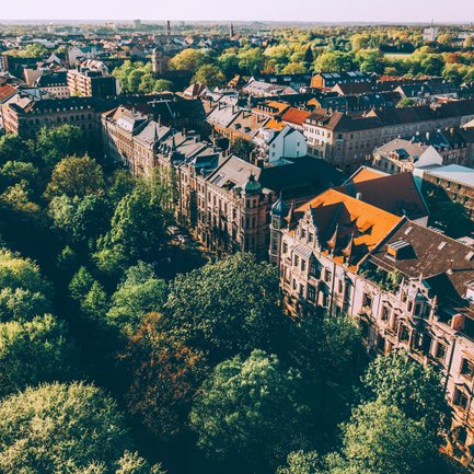 Sonnenbeschienene Sandsteinfassaden der Fürther Hornschuchpromenade mit grüner Umgebung