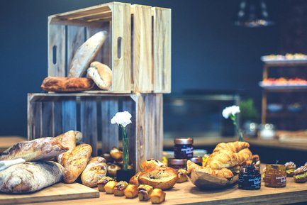 Tagungs-Catering mit Brot, Gebäck, Marmelade und Holzkisten an ansprechend dekoriertem Buffet