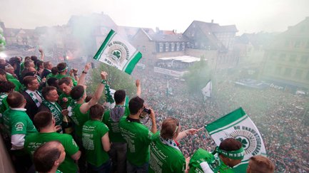 Große Menschenmenge in Fürth feiert mit grünen SpVgg-Fürth-Fahnen und Shirts in der Innenstadt