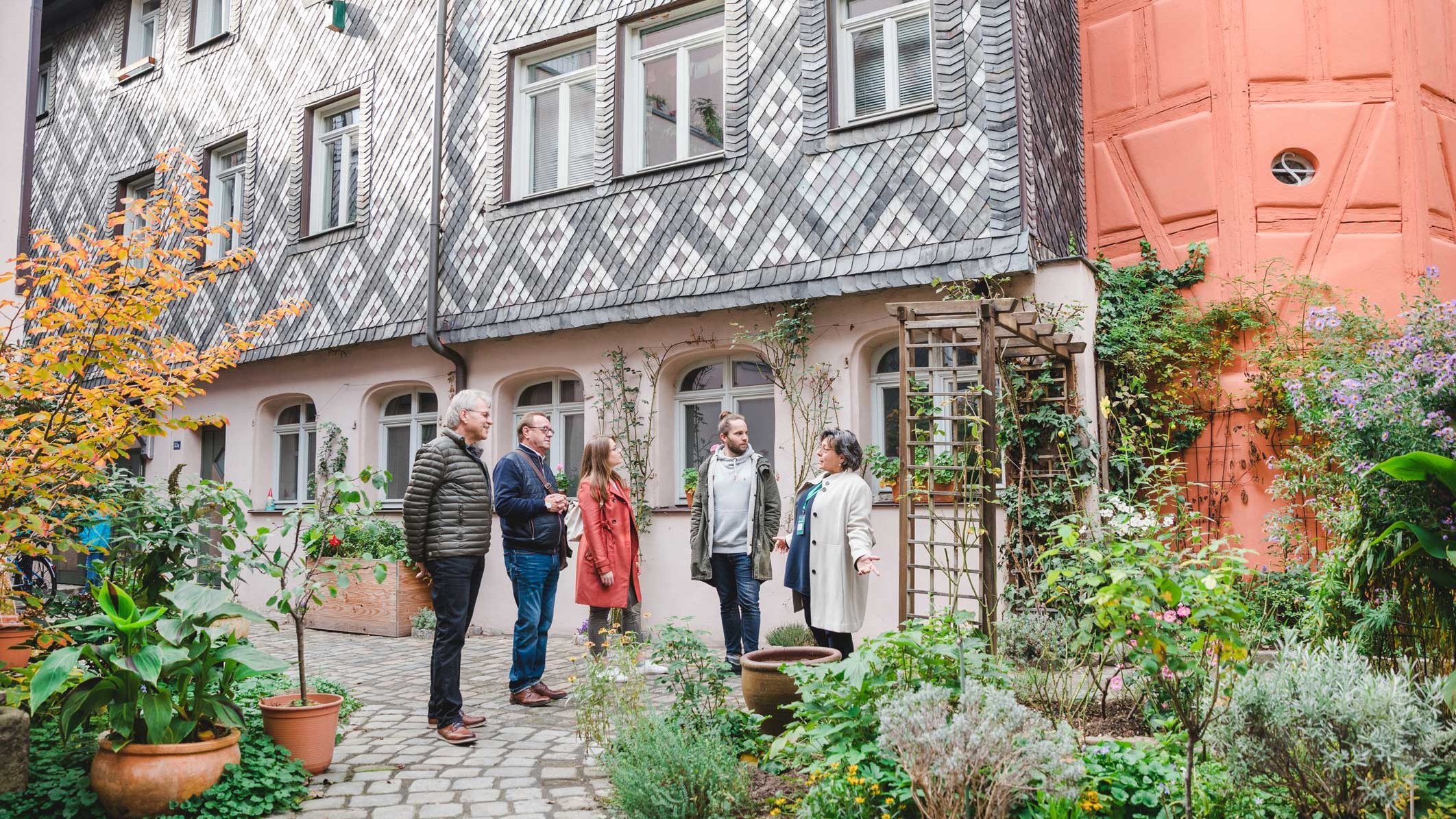 Gruppe im historischen Hof der Fürther Altstadt hört der Stadtführerin bei Erklärungen zu.
