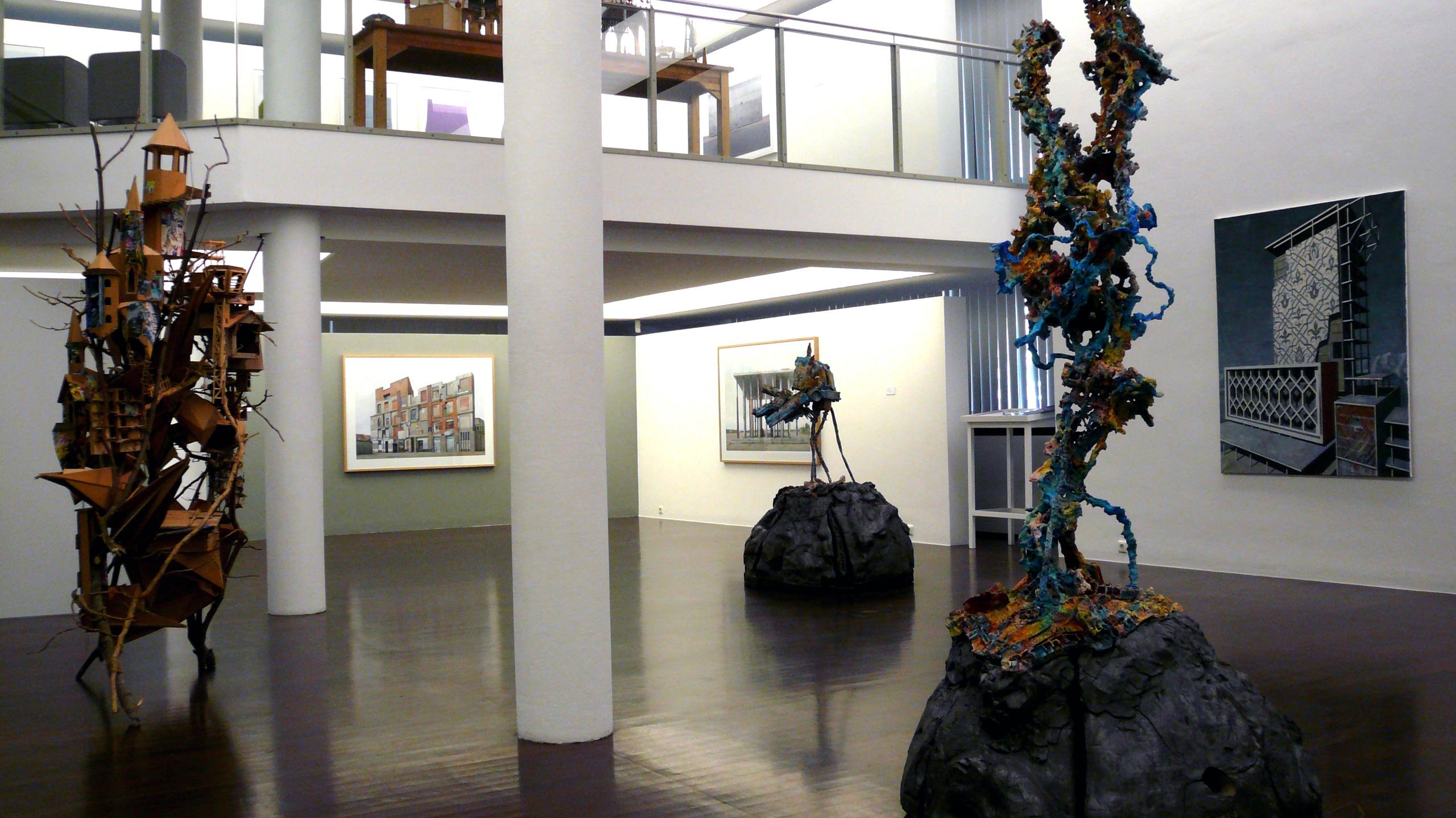 Drei Skulpturen im Raum der Kunstgalerie Fürth, ergänzt durch Gemälde an den Wänden.