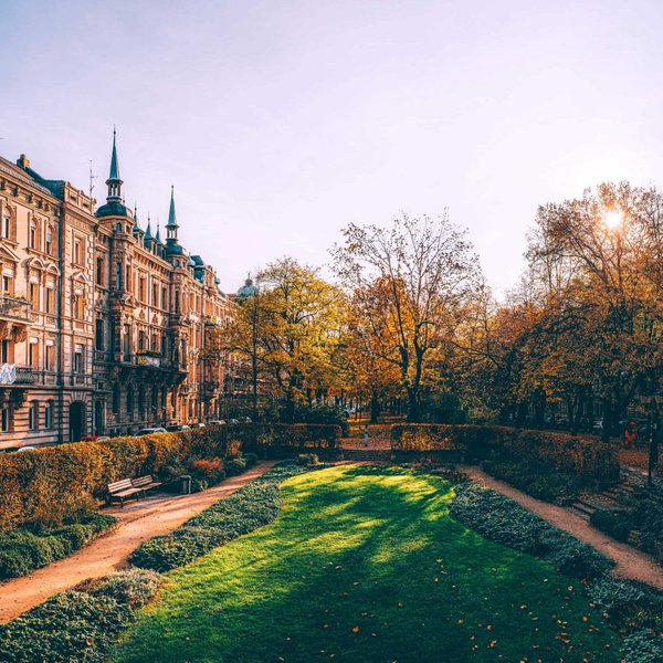 Die Fürther Hornschuchpromenade an einem sonnigen Herbstmorgen mit Sandsteinhäusern und der grünen Willy-Brandt-Anlage.