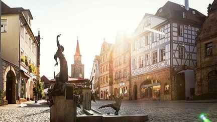 Grüner Markt in Fürth bei Sonnenschein mit Gauklerbrunnen und historischen Sandstein- und Fachwerkhäusern
