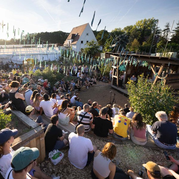 Gäste verfolgen eine Podiumsdiskussion beim Festgartenfest im Kulturgewächshaus Fürth