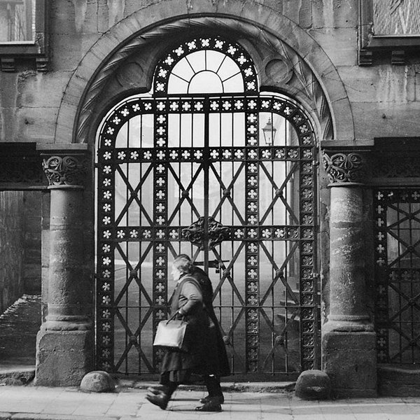 Schwarz-weiß-Foto von zwei Personen vor einem kunstvollen Gittertor, Symbol jüdischen Lebens in Fürth.