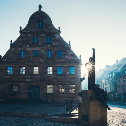 Früher Morgen am Grünen Markt in Fürth, der Gauklerbrunnen erhält erste Sonnenstrahlen