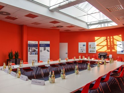 Rotes Zimmer bei Neue Materialien Fürth mit Tischen, roten Stühlen und Dachfenstern