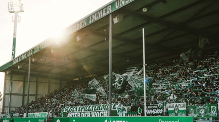Volles Stadion mit jubelnden Fans, Fahnen und Bannern beim Heimspiel von SpVgg Greuther Fürth.