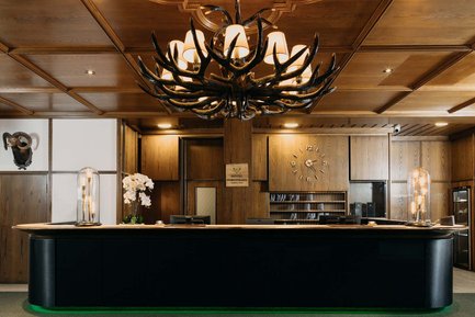 Rustikale Rezeption im Hotel Forsthaus Fürth mit Kronleuchter aus Holz, Hirschgeweih-Design und Holzdetails
