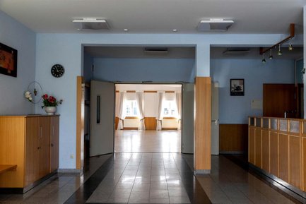 Blick vom Eingangsbereich durch weit geöffnete Türen in die Eventhalle in Burgfarrnbach