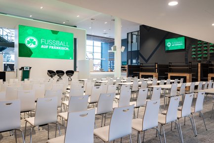 Professioneller Tagungsraum mit Teppichboden, Tischen, Stühlen und Leinwand für Präsentationen