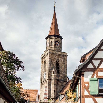 Zwischen charmanten Fachwerkhäusern der Fürther Altstadt ist der Kirchturm von St. Michael zu sehen