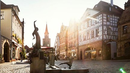 Grüner Markt in Fürth bei Sonnenschein mit Gauklerbrunnen und historischen Sandstein- und Fachwerkhäusern