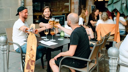 Freunde stoßen in der Fürther Gustavstraße mit einem Bier an