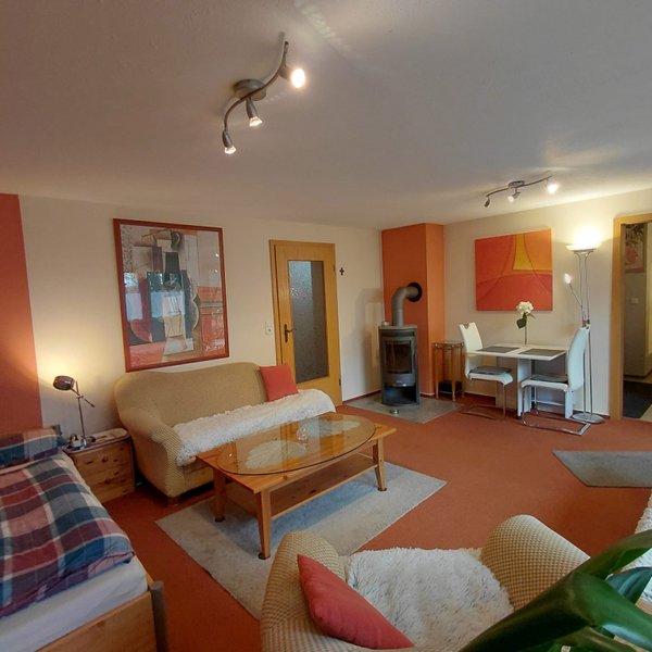 Gemütliches Wohnzimmer mit orangefarbenem Farbkonzept in der Ferienwohnung Anita Pfeiffer im Landkreis Fürth