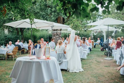 Garten im Logenhaus Fürth mit rund gedeckten Tischen, Sonnenschirmen und Bäumen bei Hochzeit