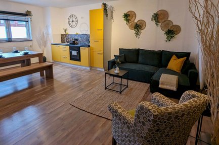 Wohnküche der Ferienwohnung Feld & Flair in Fürth mit gelber Küche als Blickfang