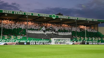 Fans zeigen große grün-weiße Choreografie im Stadion der SpVgg Greuther Fürth hinter dem Torbereich