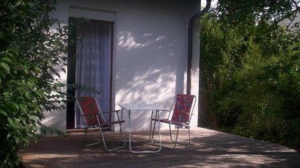 Kleine Terrasse im Apartment Falke in Fürth mit Sitzmöbeln im grünen Garten