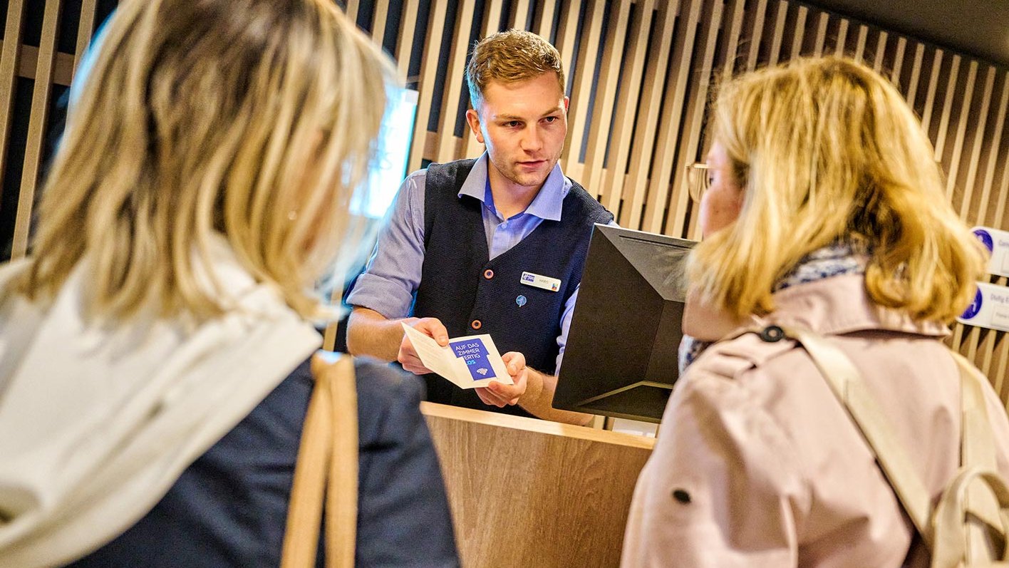Freundlicher Empfang an der Hotelrezeption: Zwei Touristinnen bekommen ihre Zimmerkarte.