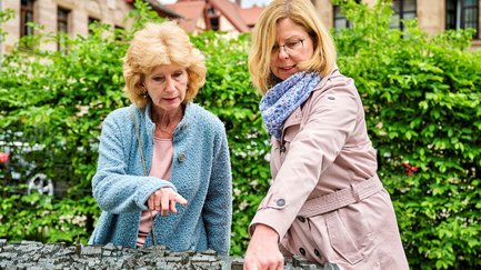 Zwei Touristinnen stehen vor dem taktilen Stadtplan in der Fürther Altstadt und orientieren sich