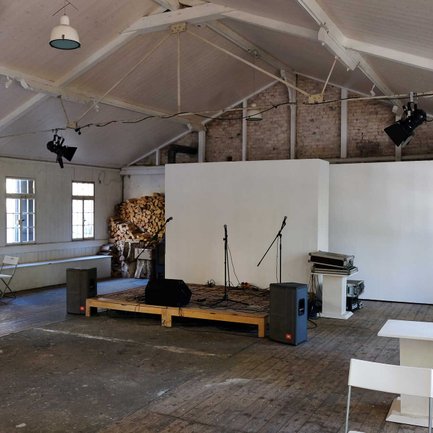 Auf der Bühne am Kulturort Badstraße in Fürth stehen Mikrofone und Boxen bereit für ein bevorstehendes Konzert