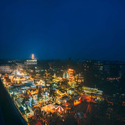 Weihnachtsmarkt auf der Fürther Freiheit mit vielen beleuchteten Buden und Besuchern, die durch die Gänge schlendern.