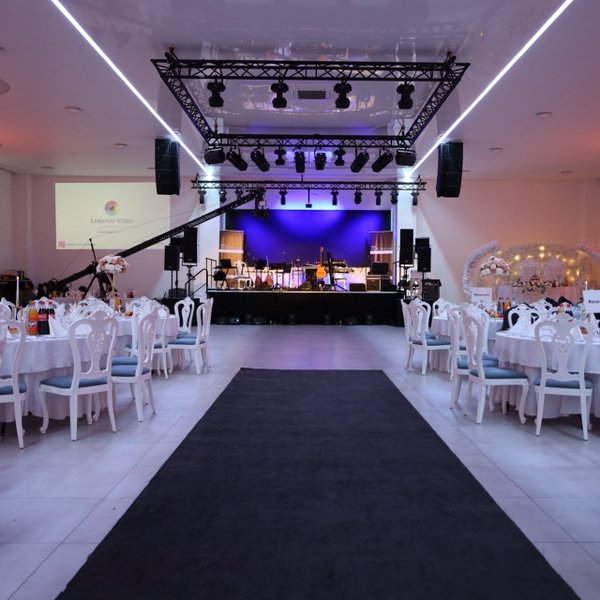 Festlich gedeckte Tische im First Class Event Fürth mit Blick auf Bühne, Technik und stimmungsvolle Beleuchtung