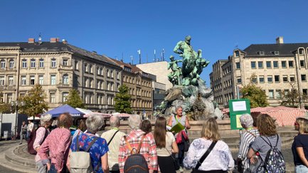 Stadt(ver)führerin erklärt ihrer Gruppe den Centaurenbrunnen beim Führungsmarathon in Fürth.