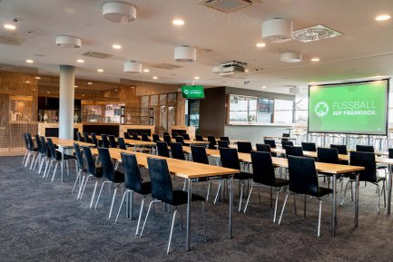 Professioneller Tagungsraum mit Teppichboden, Tischen, Stühlen und Leinwand für Präsentationen