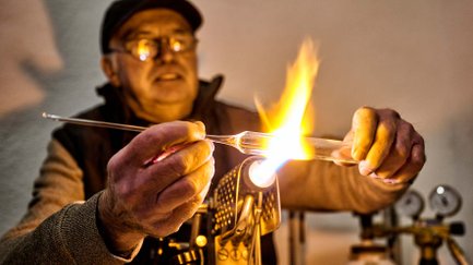 Ein Glasbläser erhitzt ein Stück Glas über einer offenen Flamme auf der Altstadtweihnacht.