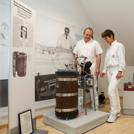 Historische erste Dialyse wird im Fürther Dialysemuseum von zwei Personen betrachtet