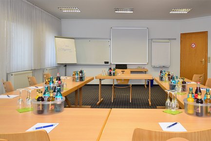 Heller Tagungsraum im Landhotel Seerose mit Holztischen, Stühlen, großen Fenstern und Getränken auf den Tischen