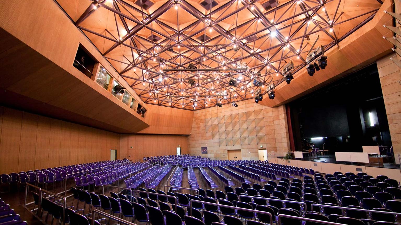 Großer Saal der Stadthalle Fürth mit Bestuhlung, Bühne, Holzoptik und sichtbarer Technik.