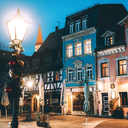 Abendliche Gustavstraße mit charmanten Hausfassaden und dem Turm von St. Michael im Hintergrund