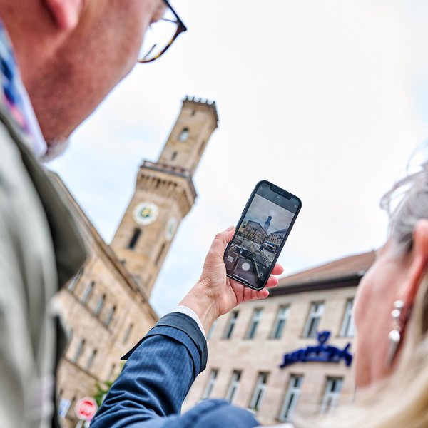 Zwei Touristen fotografieren das Fürther Rathaus vom Kohlenmarkt aus – ein beeindruckendes Wahrzeichen.