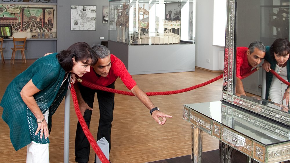 Zwei Best-Ager besuchen das Fürther Stadtmuseum und betrachten ein historisches Ausstellungsstück.