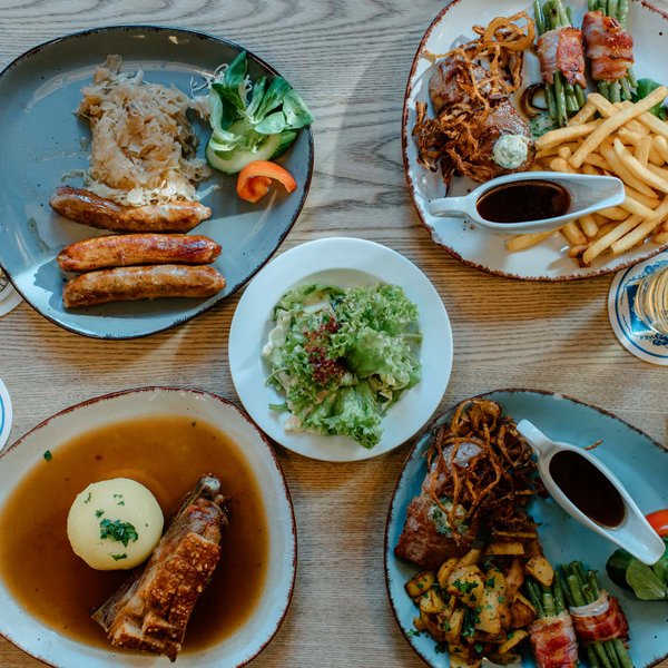 Verschiedene fränkische Gerichte wie Bratwurst, Schäuferle, Salat, Bier und Wein in Fürth