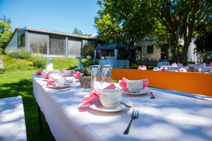 Garten im Landhotel Seerose mit Bank, weißer Husse und gedeckten Kaffeetassen für Gäste