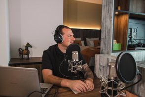 Mitarbeiter der Tourist-Information sitzt vor Mikrofon und spricht in einem Podcast über Fürth