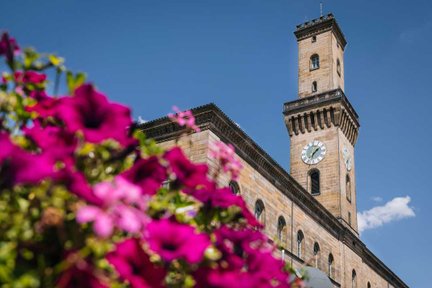 Fürther Rathaus mit markantem Rathausturm, farbenfrohe Blumen im Vordergrund