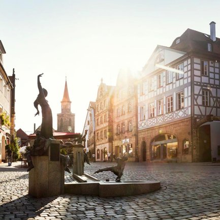 Blick über den Grünen Markt in Fürth, während die Sonne hinter der Kirche St. Michael aufgeht